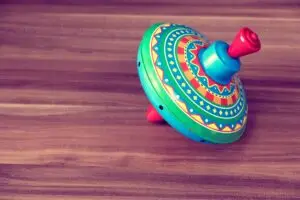 Brightly colored vintage spinning top toy on a wooden table, evoking childhood memories and playful nostalgia.