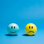 Two smiley balls representing opposite emotions on a blue background.