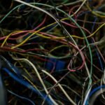 Close-up of multicolored tangled electric wires conveying chaos and complexity.