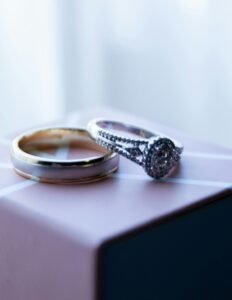 Close-up of luxurious diamond and gold wedding rings on a decorative box.