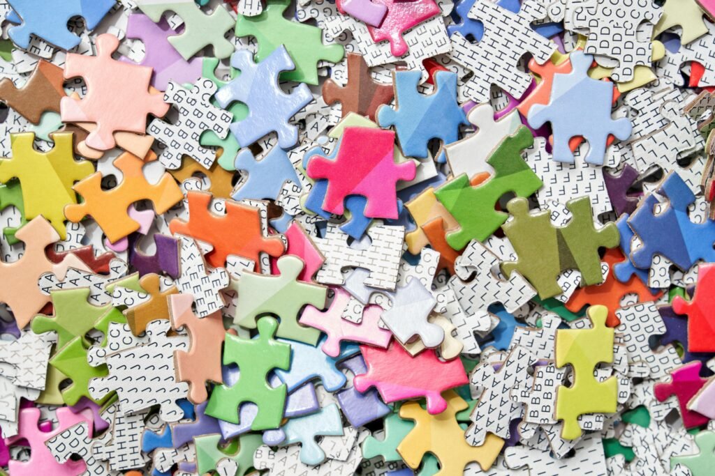 Vibrant, scattered jigsaw puzzle pieces creating an abstract, playful pattern.