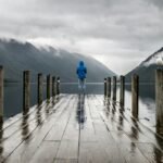 person standing on brown wooden dock